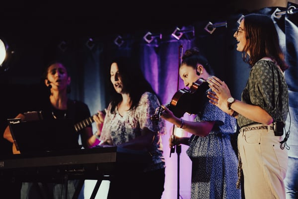 four-friends-playing-music-on-stage-1