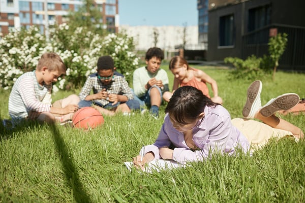 teens writing on grass